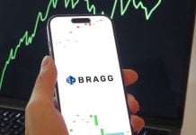 Un celular con el logo de Bragg Gaming frente a un gráfico financiero ascendente.