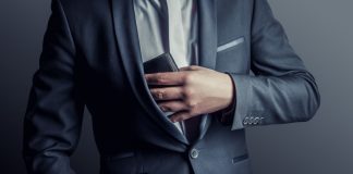 Un hombre saca su billetera del bolsillo, como hará Luckia para pagar por los costos del IVA sobre apuestas.