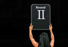 Una mujer alza un cartel de ROUND 2.