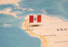La bandera de Perú clavada sobre el país en un mapa.