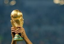 Dos brazos alzan la Copa del Mundo.