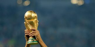 Dos brazos alzan la Copa del Mundo.