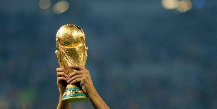 Dos brazos alzan la Copa del Mundo.