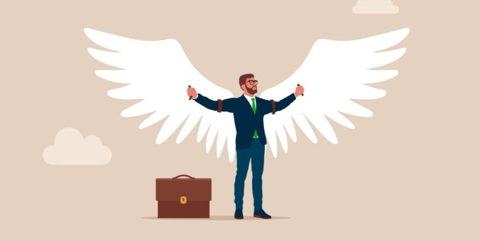 Un hombre de negocios abre sus brazos, con alas de ángel a su espalda.