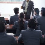 Personas con traje asisten a una clase.