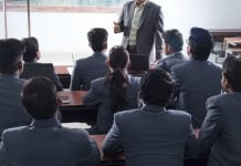 Personas con traje asisten a una clase.