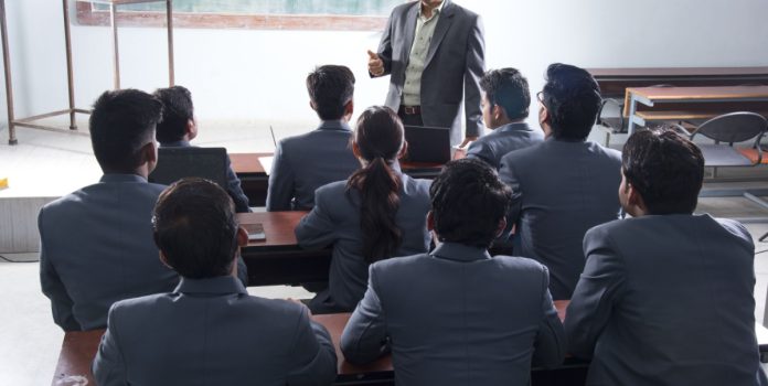 Personas con traje asisten a una clase.