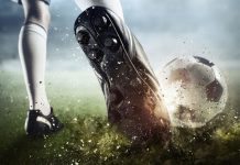 Un futbolista patea una pelota de fútbol.