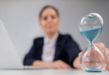 Una mujer da vuelta un reloj de arena.