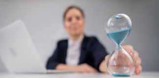 Una mujer da vuelta un reloj de arena.