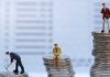 Gente en miniatura, de pie sobre pilas de monedas.