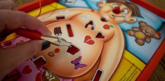 Una mano juega al juego de mesa "Operando".