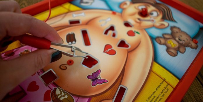 Una mano juega al juego de mesa "Operando".