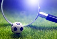 Una lupa observa una pelota de fútbol.