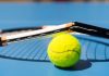 Una raqueta de tenis rota sobre una pelota.