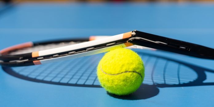 Una raqueta de tenis rota sobre una pelota.