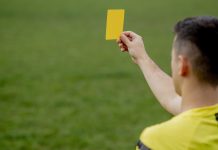 árbitro mostrando tarjeta amarilla